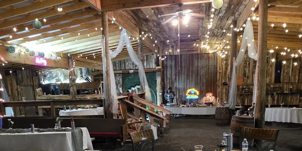 Tables, tulle and string lights set for a reception inside the Rockin' T Ranch barn